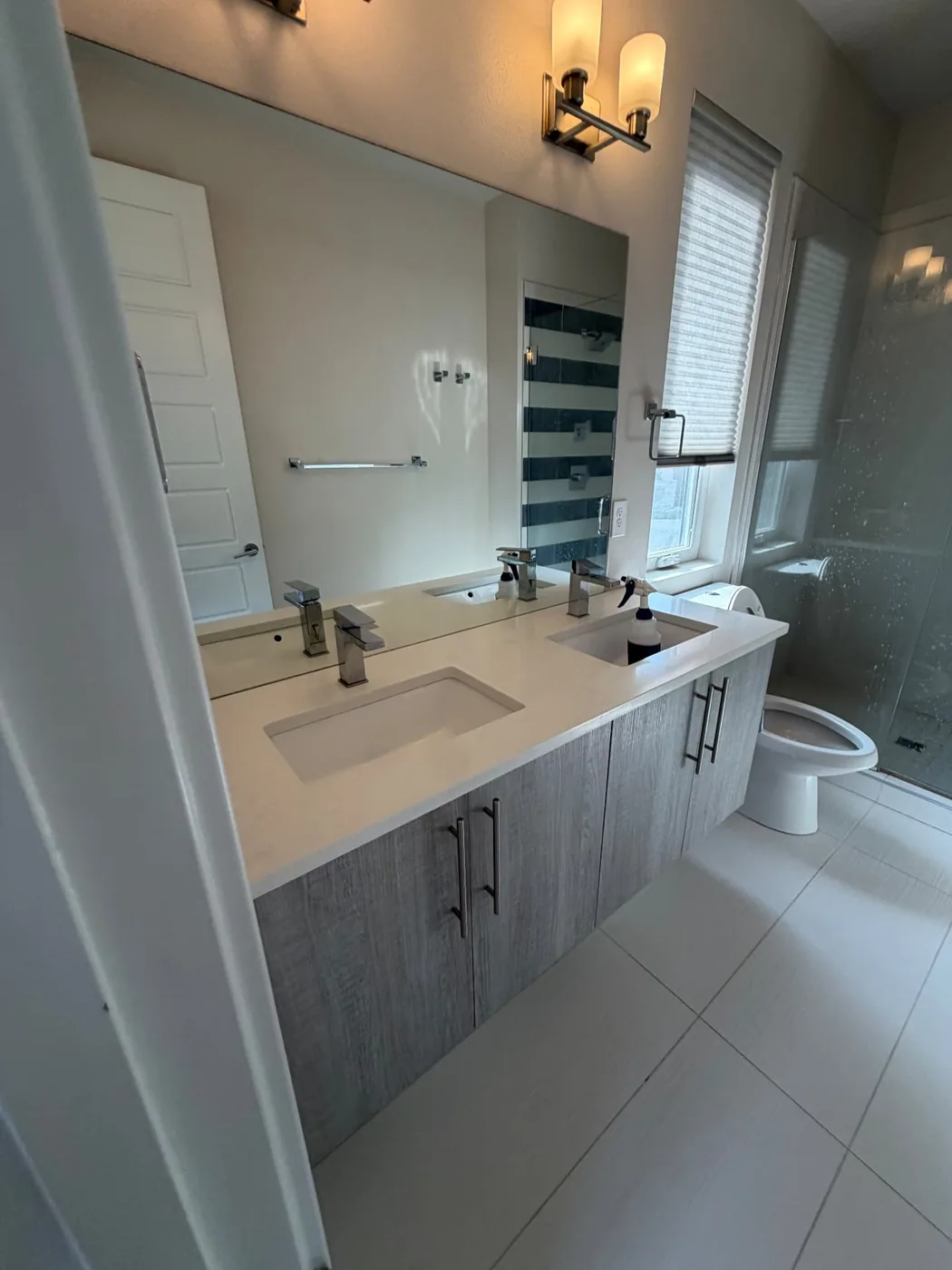 Modern bathroom with a floating vanity and clear glass shower door after a deep clean