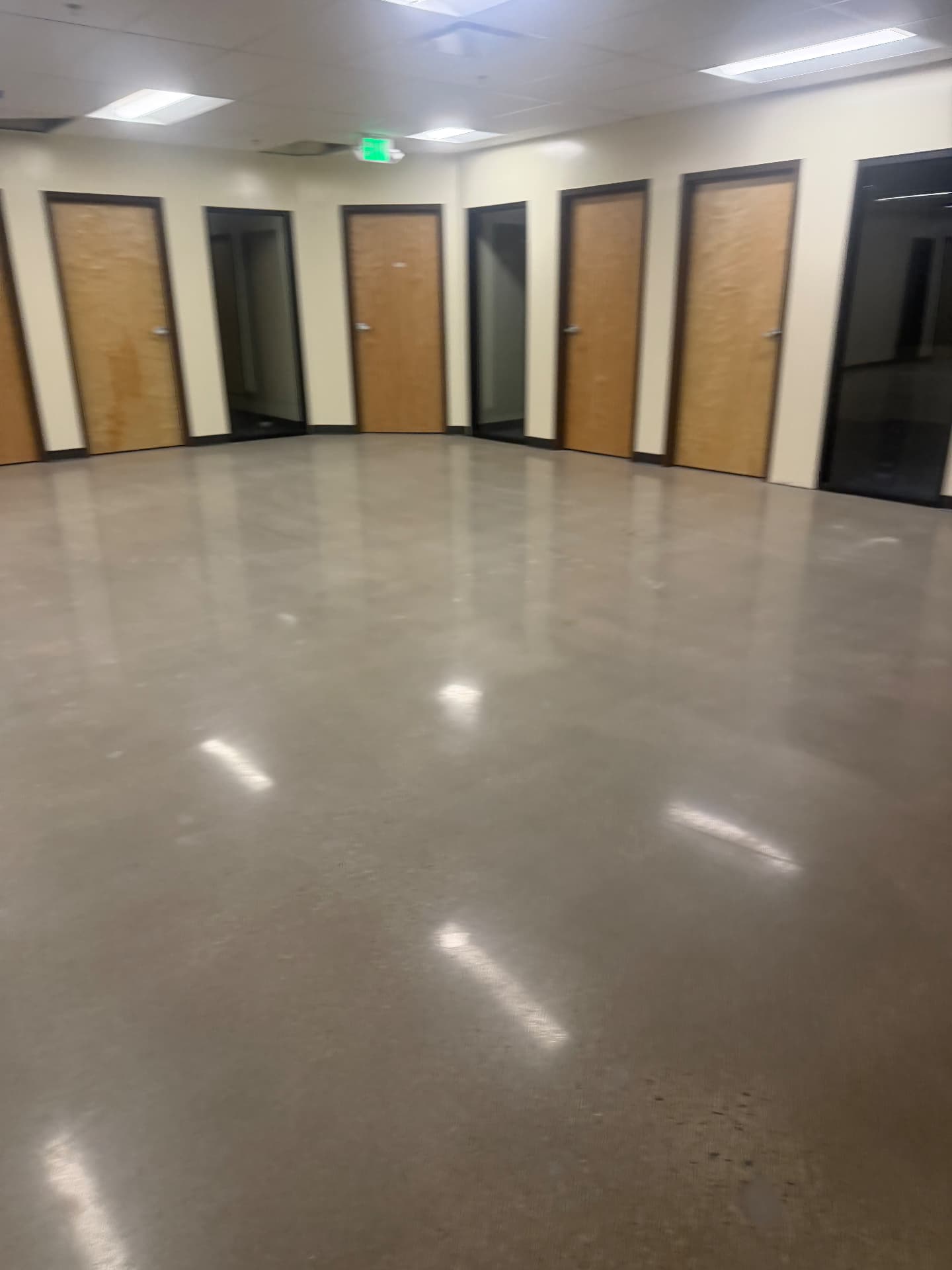 Commercial office corridor with clean polished concrete and wood doors after final construction cleaning