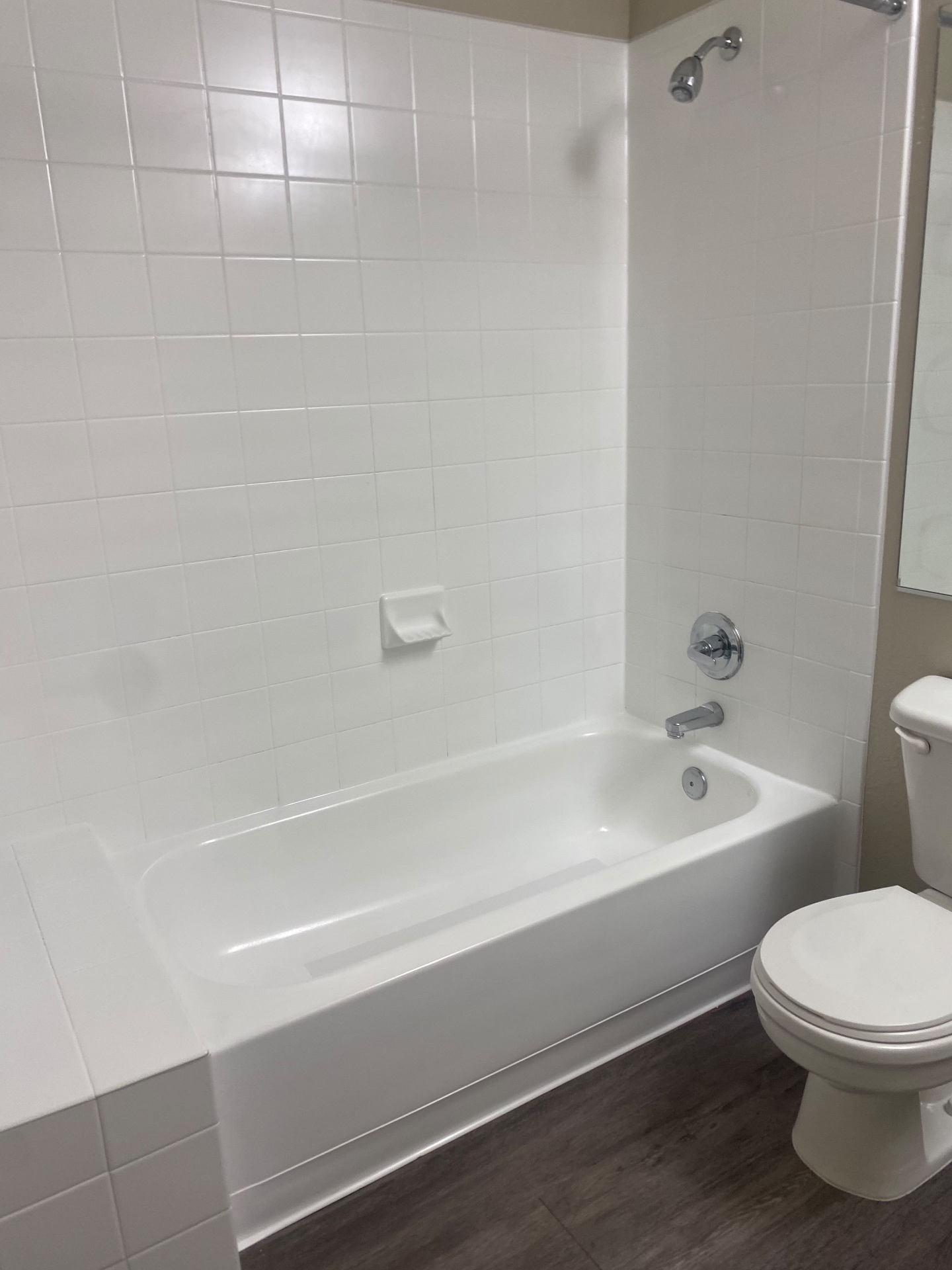 White tile tub surround, tub and toilet cleaned during a move-out cleaning