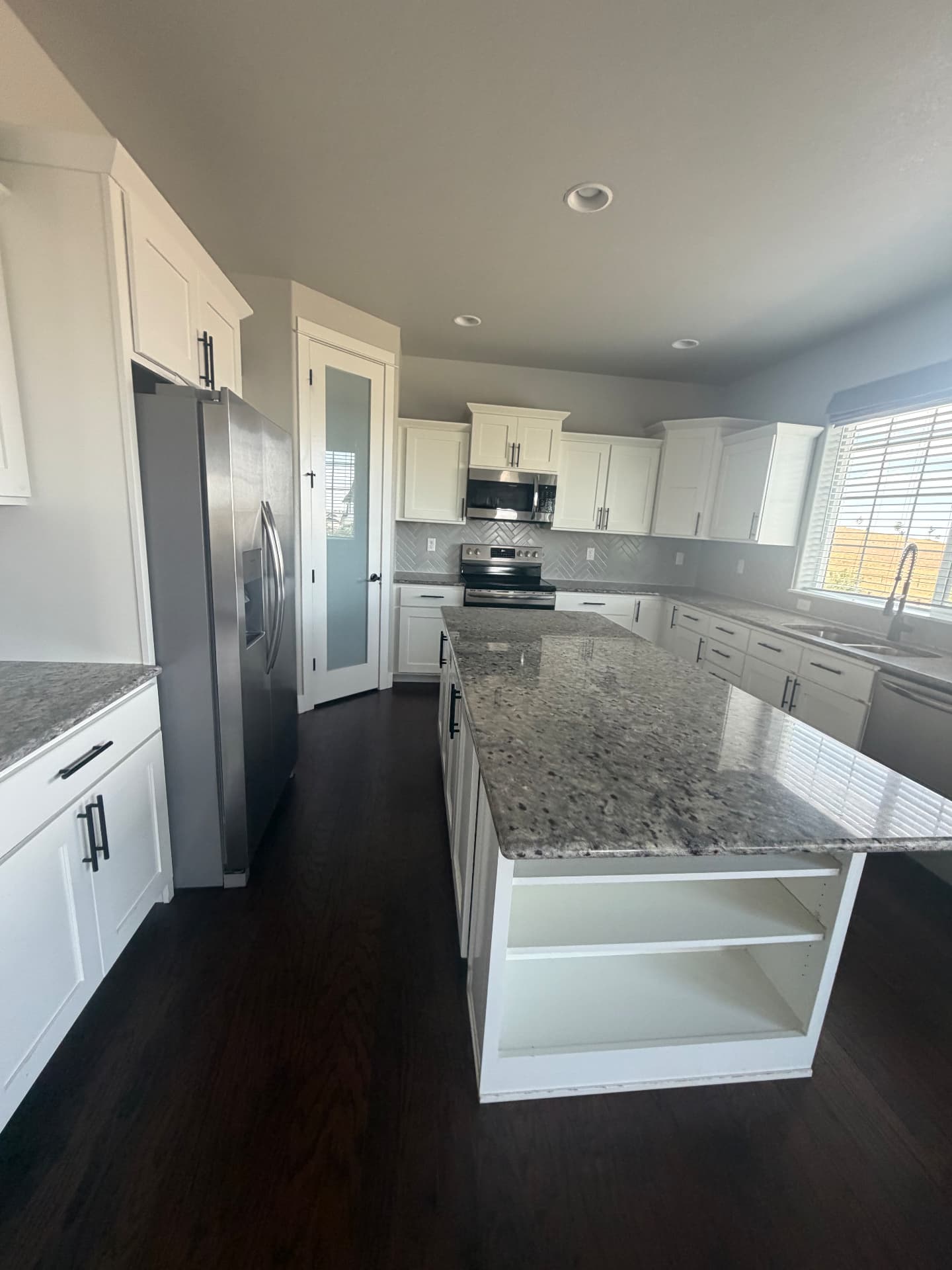 Move-out kitchen clean, Colorado Kitchen cleaned by Hello Clean & Company with polished granite island, white cabinets and stainless appliances