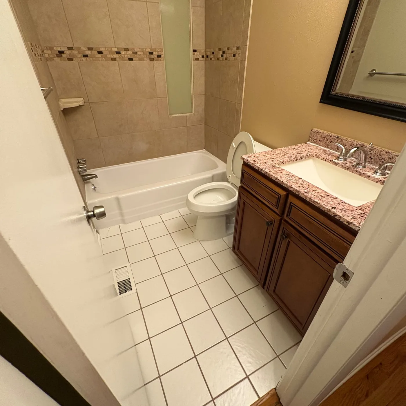Guest bathroom with a granite vanity and tiled tub area cleaned top to bottom