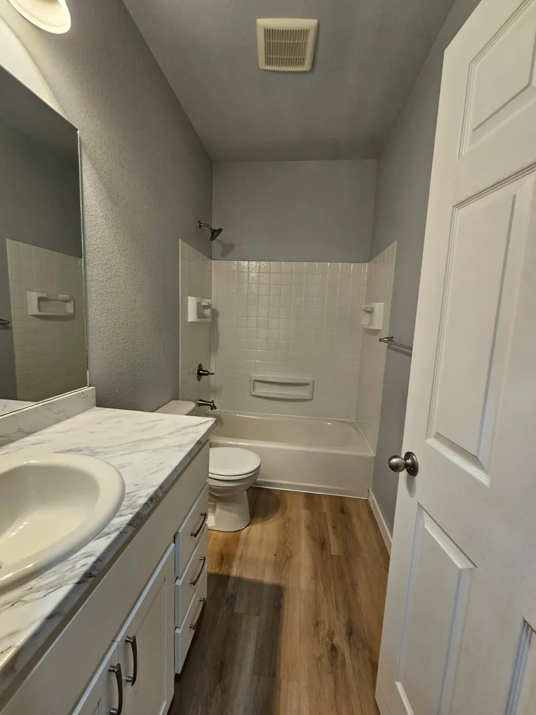 Marble-look vanity top and white tiled shower after a one-time deep clean in a Colorado home